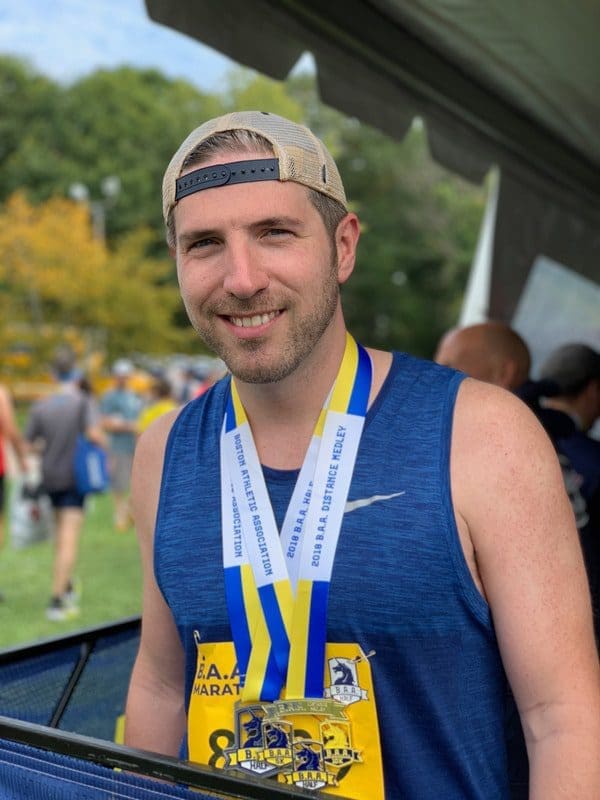 Dr. Taylor Horst after half-marathon with multiple medals around his neck